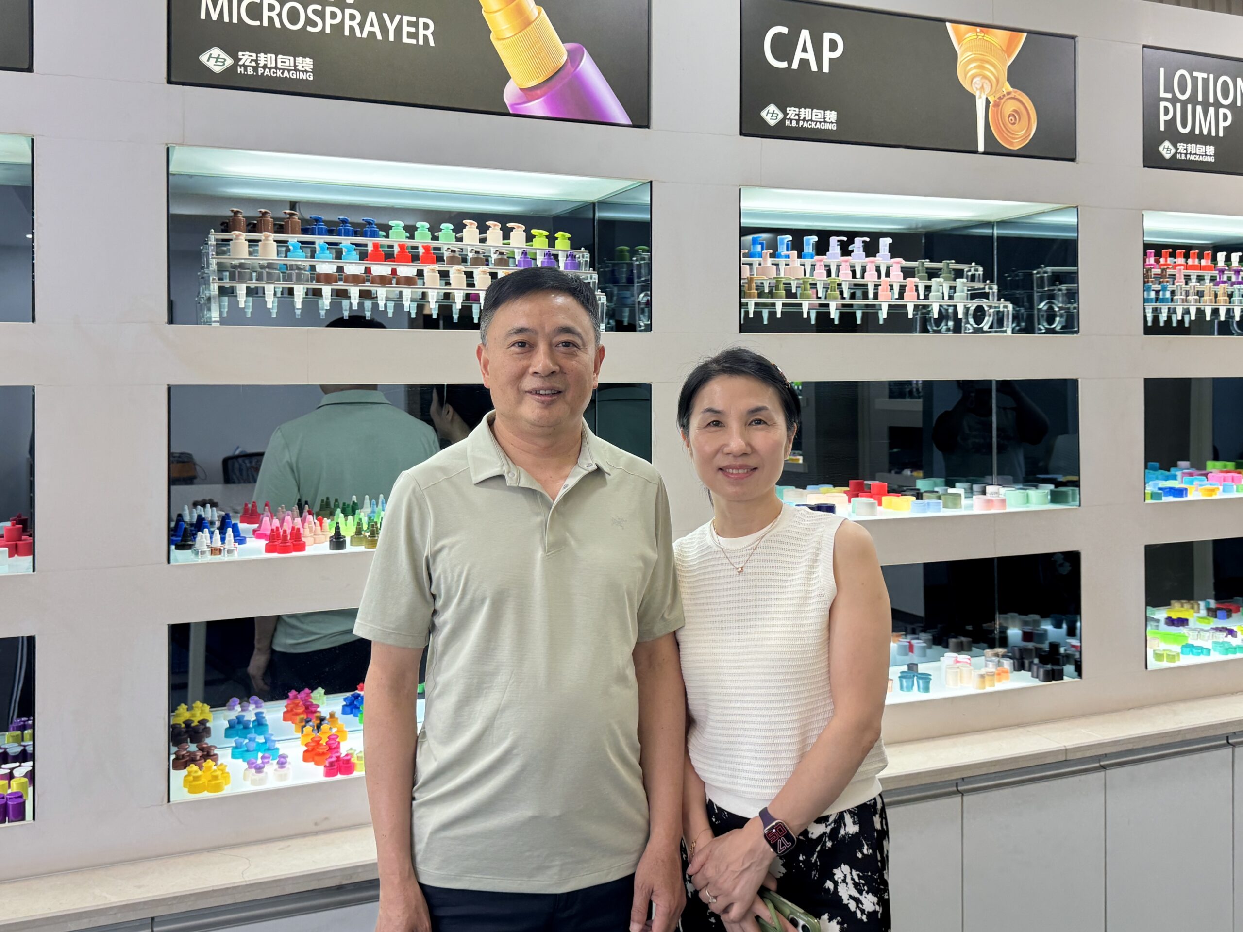 HB Packaging's founders in the company showroom, surrounded by cap and pump displays